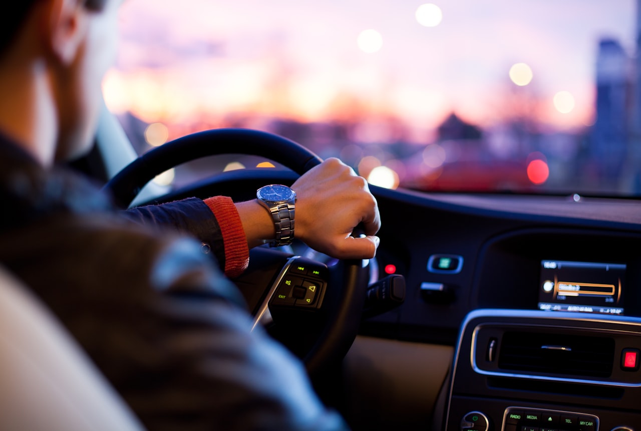 Professional chauffeur driving at dusk